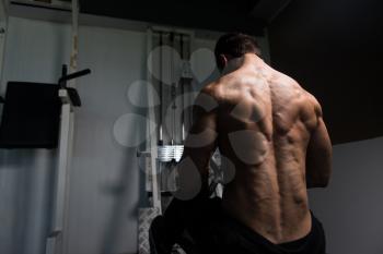 Handsome Bodybuilder Doing Heavy Weight Exercise For Back On Machine