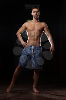 Portrait Of A Young Physically Fit Nerd Man Showing His Well Trained Body - Muscular Athletic Bodybuilder Fitness Model Posing After Exercises