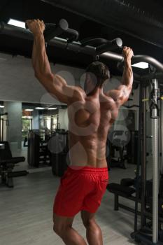 Young Man Athlete Doing Pull Ups - Chin-Ups In The Gym