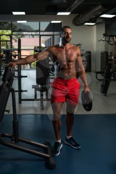 Portrait Of A Physically Italian Man Holding Weights In Hand