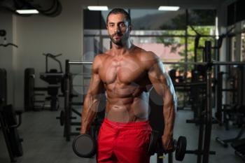 Bodybuilder Working Out Biceps In A Dark Gym - Dumbbell Concentration Curls