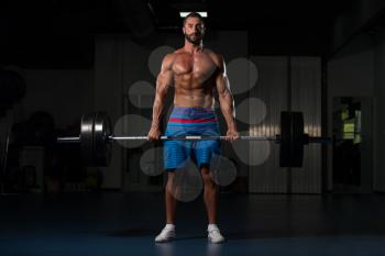 Latin Bodybuilder Doing Heavy Weight Exercise For Back With Barbell In Modern Gym