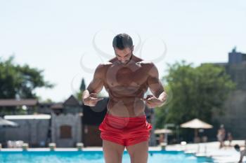 Portrait Of A Physically Fit Man Showing Abs Outdoors