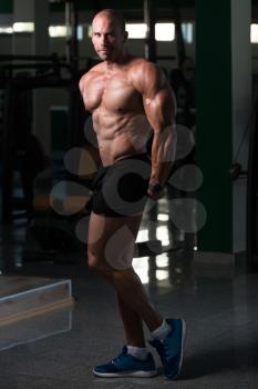 Bald Man Standing Strong In The Gym And Flexing Muscles - Muscular Athletic Bodybuilder Fitness Model Posing After Exercises