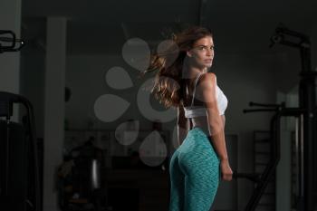 Fitness Woman Standing Strong In The Gym And Flexing Muscles - Muscular Athletic Bodybuilder Model Posing After Exercises