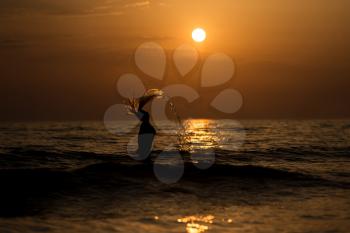 Girl Throwing Water With Her Wet Hair in the Ocean During Sunset - Copy Space Text