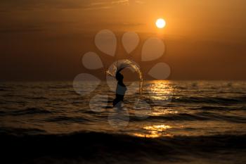 Girl Throwing Water With Her Wet Hair in the Ocean During Sunset - Copy Space Text