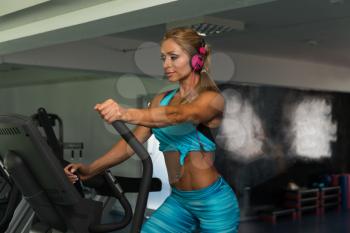 Attractive Mature Woman Doing Aerobics Elliptical Walker In Modern Fitness Center