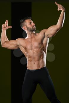 Healthy Man Standing Strong In The Gym And Flexing Muscles - Muscular Athletic Bodybuilder Fitness Model Posing After Exercises