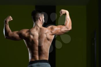 Healthy Man Standing Strong In The Gym And Flexing Muscles - Muscular Athletic Bodybuilder Fitness Model Posing After Exercises