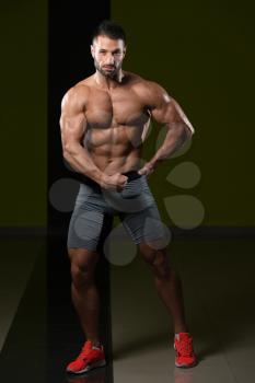 Healthy Man Standing Strong In The Gym And Flexing Muscles - Muscular Athletic Bodybuilder Fitness Model Posing After Exercises