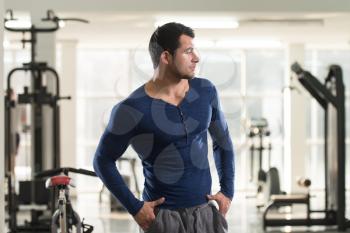 Handsome Young Man Standing Strong in Blue T-shirt and Flexing Muscles - Muscular Athletic Bodybuilder Fitness Model Posing After Exercises