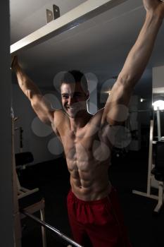 Handsome Man Standing Strong In The Gym And Flexing Abdominal Muscles - Muscular Athletic Bodybuilder Fitness Model Posing After Exercises