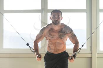 Bodybuilder Is Working On His Chest With Cable Crossover In Gym