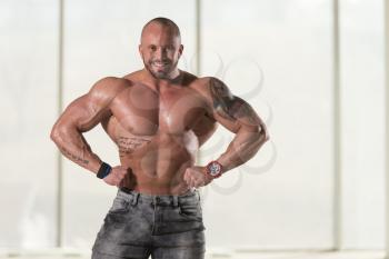 Healthy Young Tattoo Man Standing Strong In Pants And Flexing Muscles - Muscular Athletic Bodybuilder Fitness Model Posing After Exercises