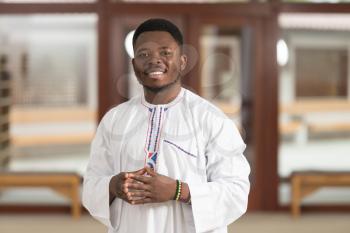 Portrait Of A African Muslim Man Making Traditional Prayer To God While Wearing A Traditional Cap Dishdasha