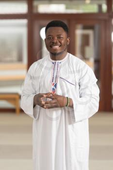 Portrait Of A African Muslim Man Making Traditional Prayer To God While Wearing A Traditional Cap Dishdasha