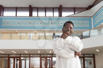 Portrait Of A African Muslim Man Making Traditional Prayer To God While Wearing A Traditional Cap Dishdasha