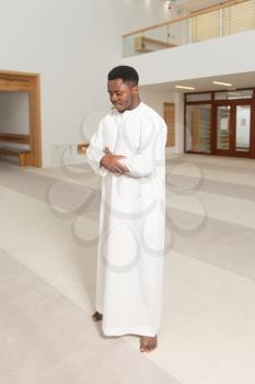 African Muslim Man Making Traditional Prayer To God While Wearing A Traditional Cap Dishdasha