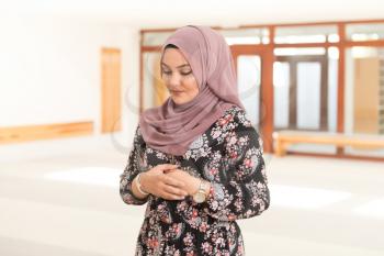 Muslim Woman Making Traditional Prayer To God In Mosque