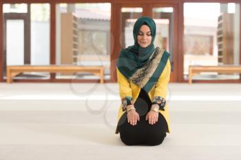 Muslim Woman Making Traditional Prayer To God In Mosque