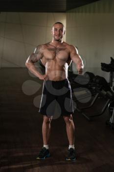 Muscular Man Showing Thumbs Up While Standing Strong In A Gym And Flexing Muscles - Muscular Athletic Bodybuilder Fitness Model Posing After Exercises