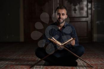 Adult Muslim Man Is Reading The Koran In The Mosque