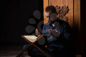 Adult Muslim Man Is Reading The Koran In The Mosque