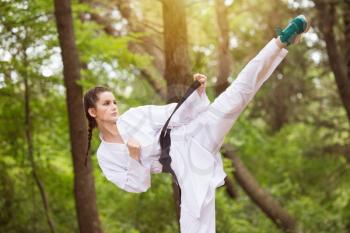 Young Woman Dressed In Traditional Kimono Practicing Her Karate Moves in Wooded Forest Area - Black Belt
