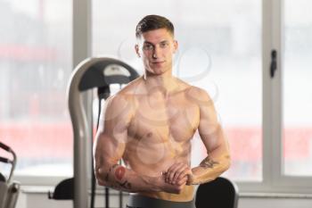 Healthy Young Tattoo Man Standing Strong In The Gym And Flexing Muscles - Muscular Athletic Bodybuilder Fitness Model Posing After Exercises