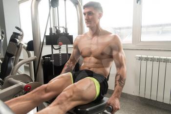 Leg Exercises Close Up -  Man Doing Leg With Machine In Gym