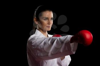 Young Muslim Woman In Traditional Kimono Practicing Her Karate Moves - Isolated On Black Background