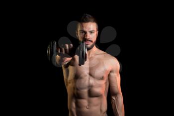 Young Man Working Out Shoulders With Dumbbells On Black Background