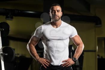Portrait Of A Young Physically Fit Man Showing His Well Trained Body In White Shirt - Muscular Athletic Bodybuilder Fitness Model Posing After Exercises