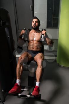Man Performing Abdominals Exercising On Machine In A Fitness Club