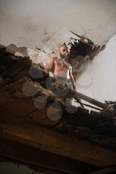 Action Hero Muscled Man Holding Machine Gun - Standing In Abandoned Building Wearing Army Pants