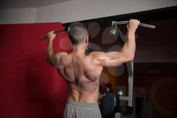 Man Athlete Doing Pull Ups - Chin-Ups In The Gym