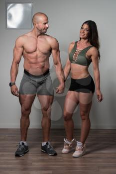 Portrait Of A Physically Fit Couple Showing Their Well Trained Body - Muscular Athletic Bodybuilder Fitness Model Posing After Exercises
