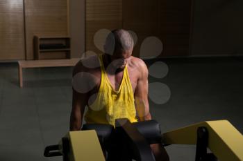 Man Doing Heavy Weight Exercise For Trapezius On Machine