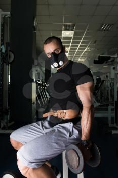Man Working Out Biceps In Elevation Mask - Dumbbell Concentration Curls