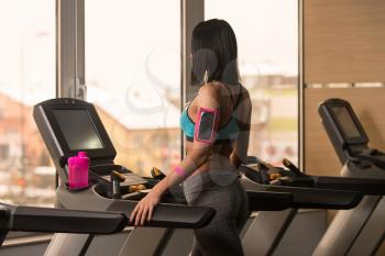Young Woman Running On Treadmill In A Modern Fitness Center