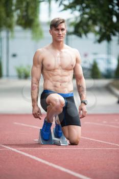 Fit and Confident Man in Starting Position Ready for Running
