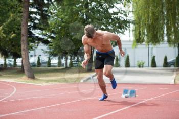 Sporty Man Running Fitness Workout on Track Exercising Outside