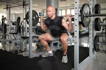 Healthy Fitness Man Working Out Legs With Barbell In A Gym - Front Squat Exercise