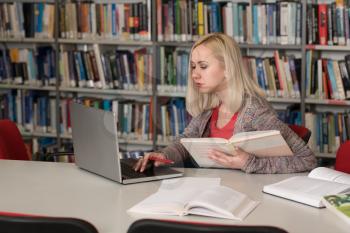 Pretty Female Student With Books Working in a High School Library