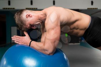 Young Man Athlete Doing Abs Exercise On Ball As Part Of Bodybuilding Training
