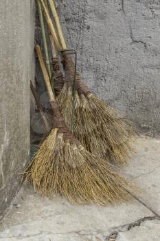 Traditional Chinese brooms against stone wall
