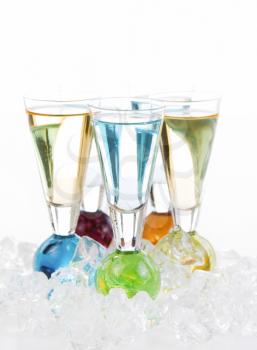 Vertical photo of mixed drinks surround by crushed ice on white background
