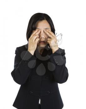 Mature Asian Woman rubbing eyes and holding glasses on white background