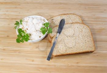 Photo of tuna fish sandwich ingredients and spread knife with natural bamboo cutting board underneath